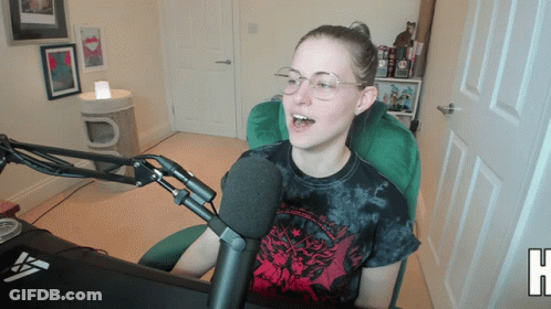 Woman In Tie Dye Shirt Sitting At Microphone GIF