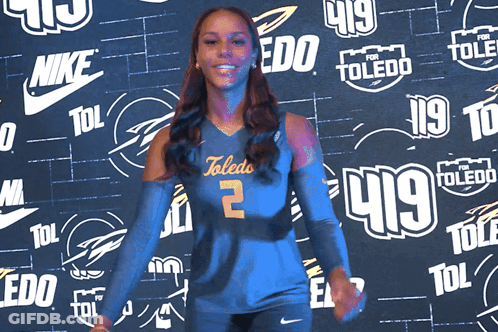 Woman In Toledo Jersey In Front Of Nike And Toledo Logos GIF