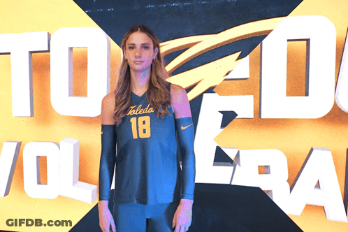 Woman In Toledo Volleyball Jersey In Front Of Sign GIF