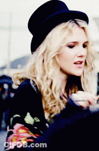 Woman In Top Hat And Floral Shirt GIF