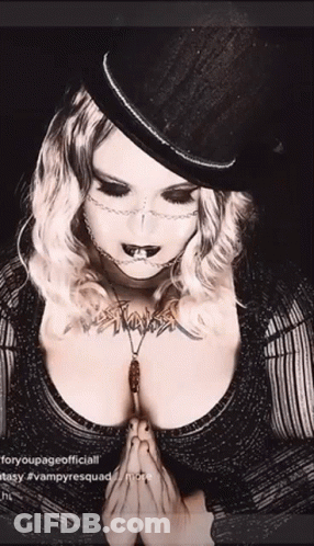 Woman In Top Hat And Necklace Praying GIF