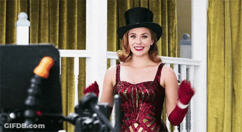 Woman In Top Hat And Red Gloves Smiling GIF