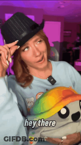 Woman In Top Hat Holding Hey There Stuffed Animal GIF