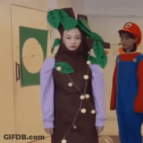 Woman In Tree Costume Next To Man In Mario Costume GIF