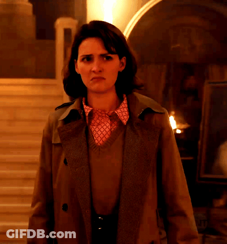 Woman In Trench Coat And Pink Shirt In Dark Room GIF