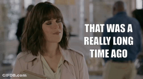 Woman In Trench Coat Holding Book Says That Was A Really Long Time Ago GIF