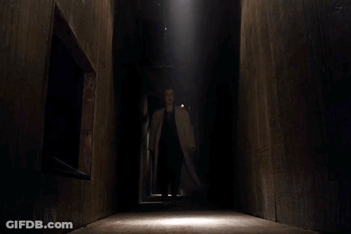 Woman In Trench Coat Standing By Lying Man GIF