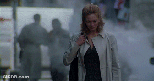 Woman In Trench Coat Walking Down Street GIF