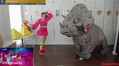 Woman In Triceratops Costume Dancing In Front Of Dynamite Twins Screen GIF
