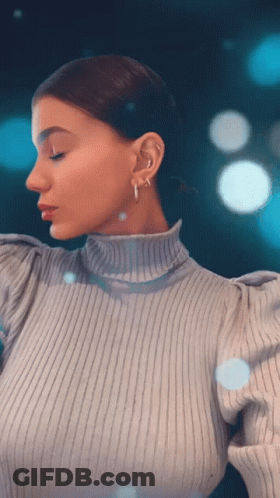 Woman In Turtleneck And Hoop Earrings Looking Down GIF