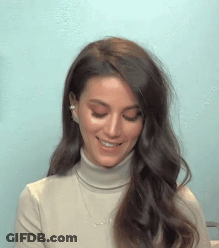 Woman In Turtleneck Smiling With Necklace GIF