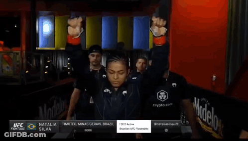 Woman In UFC Uniform Walking With Men GIF