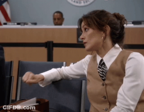 Woman In Vest And Tie Sitting In Front Of County Sign GIF