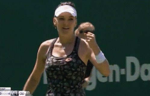 Woman In Visor And Black Tank Top In Front Of TMS Sign GIF