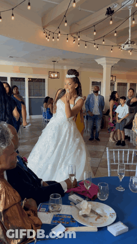 Woman In Wedding Dress From Table With Blue Tablecloth GIF