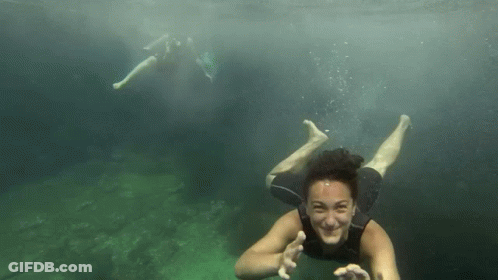 Woman In Wetsuit Swimming And Waving GIF