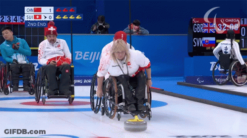 Woman In Wheelchair Throws Stone In Front Of Beijing Sign GIF
