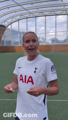 Woman In White AIA Jersey Holding Paper GIF