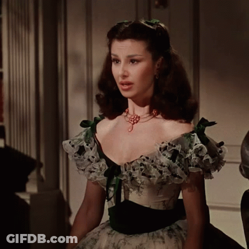 Woman In White And Green Dress With Ruffles And Necklace GIF