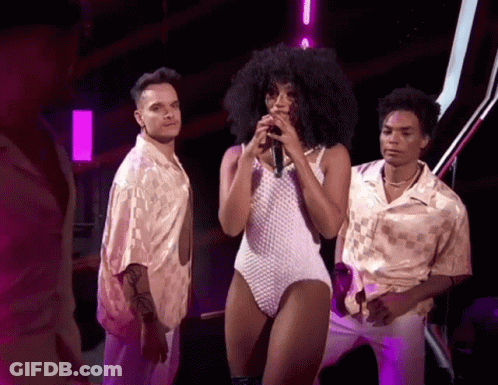 Woman In White Bodysuit Singing Into Microphone GIF