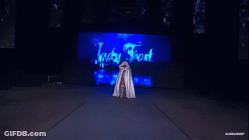 Woman In White Cape Standing Before Ice Frost Sign GIF
