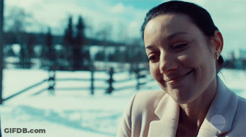 Woman In White Coat Smiling In Snow GIF