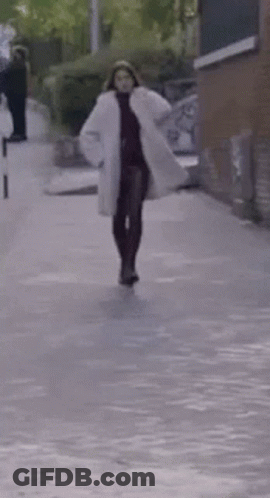 Woman In White Coat Walking GIF
