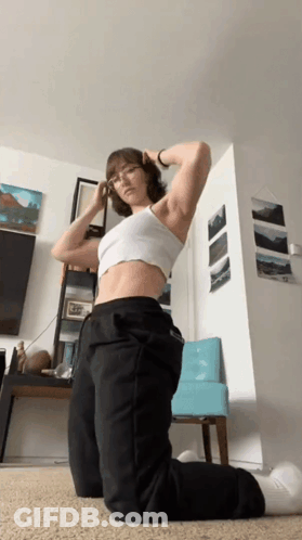 Woman In White Crop Top And Black Pants Kneeling GIF