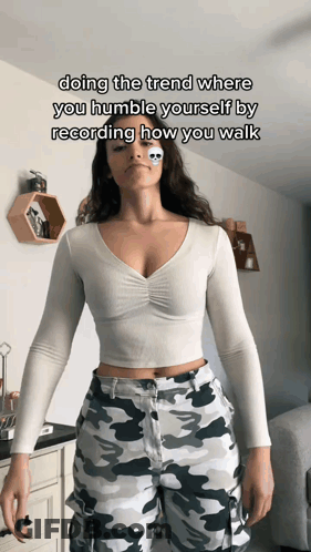 Woman In White Crop Top And Camo Pants Doing Humble Walk Trend GIF