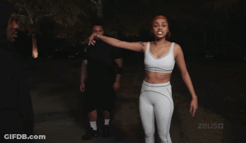 Woman In White Crop Top In Front Of Zeus Sign GIF