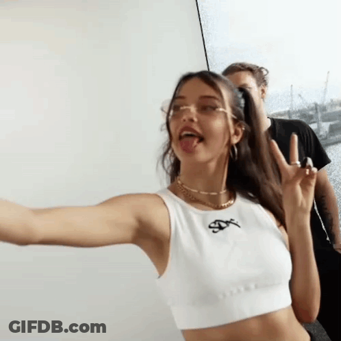 Woman In White Crop Top Making Funny Face With Man Behind Her GIF