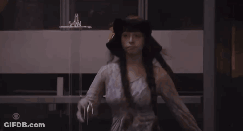 Woman In White Dress And Black Hat In Dark Room GIF