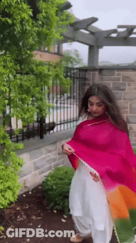 Woman In White Dress And Pink Shawl By Fence GIF
