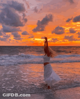 Woman In White Dress Arms Up On Beach GIF