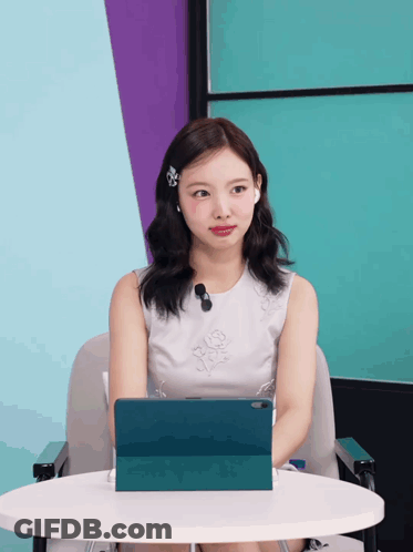 Woman In White Dress At Table With Tablet GIF