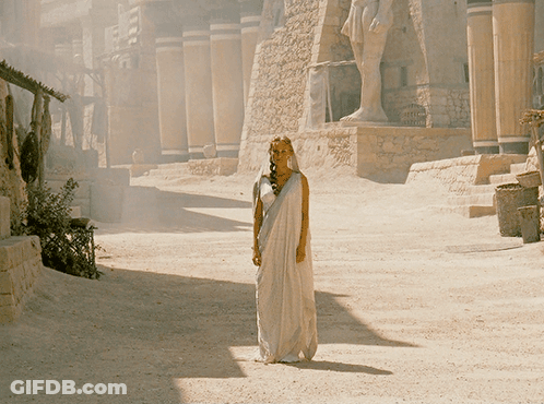 Woman In White Dress By Building GIF