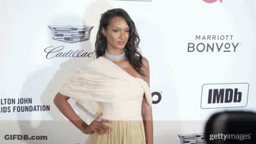Woman In White Dress By Cadillac And Marriott Bonvoy Sign GIF