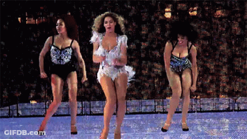 Woman In White Dress Dancing On Stage With Two Women GIF