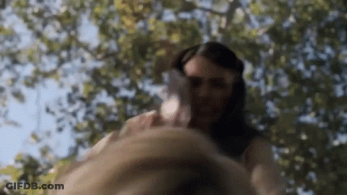 Woman In White Dress Holding Man's Hand Under Tree GIF