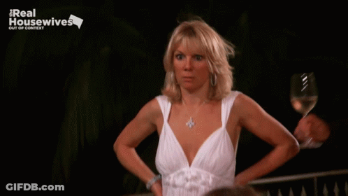 Woman In White Dress Holding Wine In Front Of Real Housewives Out Of Context Sign GIF