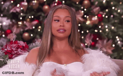 Woman In White Dress In Front Of Christmas Tree GIF