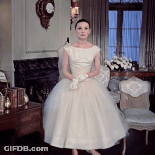 Woman In White Dress In Front Of Fireplace GIF