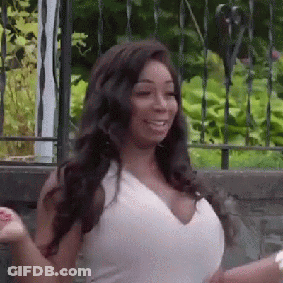 Woman In White Dress In Front Of Wrought Iron Fence GIF