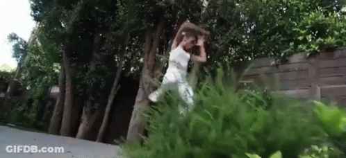 Woman In White Dress Jumping Over Tree In Park GIF