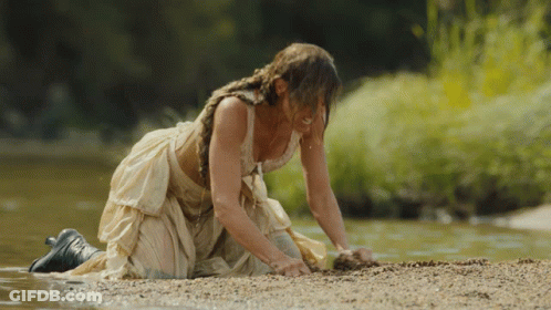 Woman In White Dress Kneeling By River GIF