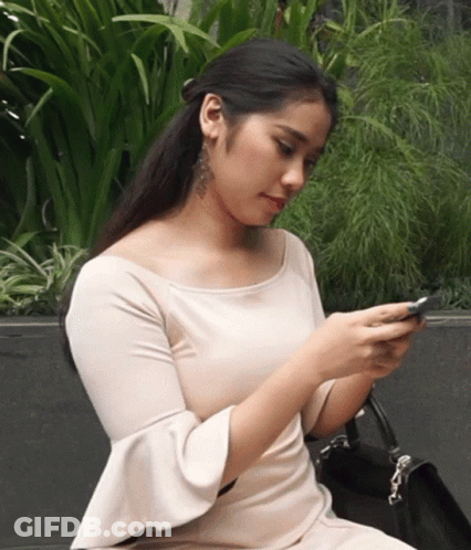 Woman In White Dress Looking At Phone GIF