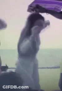 Woman In White Dress Next To Man In Purple Jacket GIF