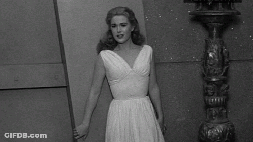 Woman In White Dress Next To Pole Black And White GIF