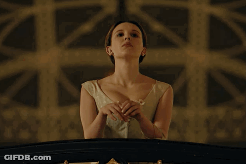 Woman In White Dress On Balcony With Hands Folded GIF
