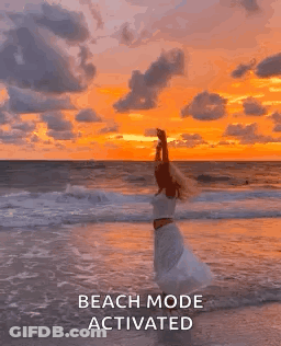 Woman In White Dress On Beach At Sunset GIF